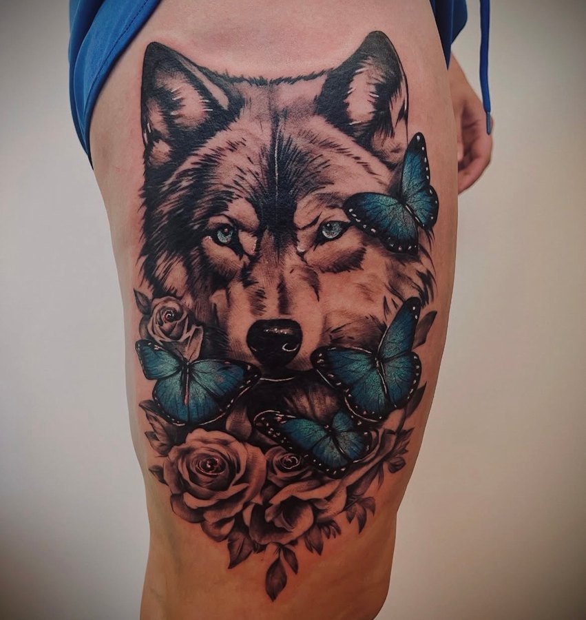 A photograph of a wolf tattoo on a thigh